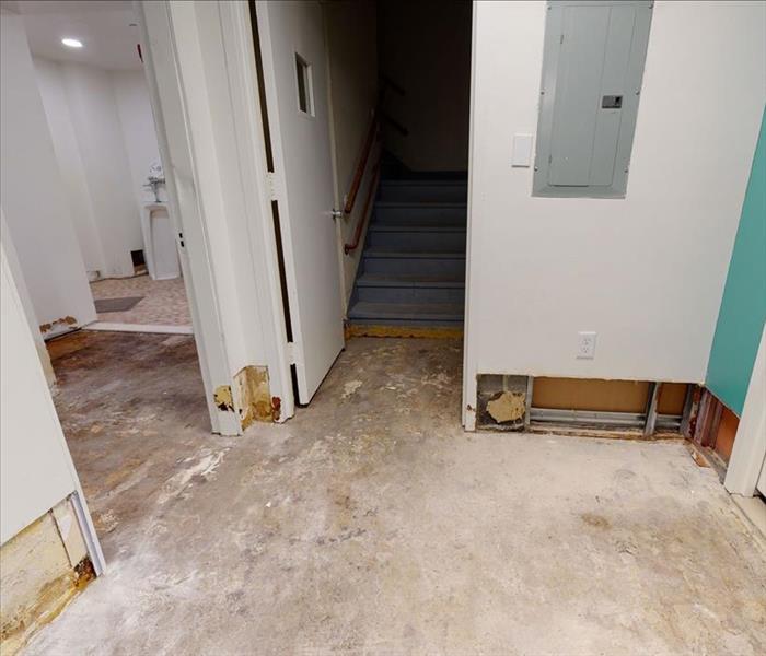 A church with stripped baseboards, flooring, and flood cuts on drywall extending into adjacent rooms