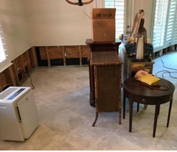 Room with water damage drying with sheetrock proactively cut at the 2-foot height from floor