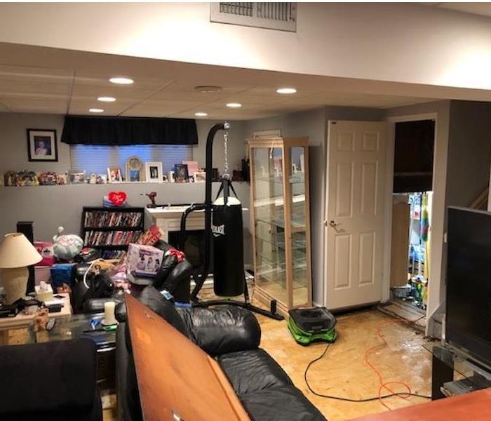 Air mover running in a living room with water on the floor