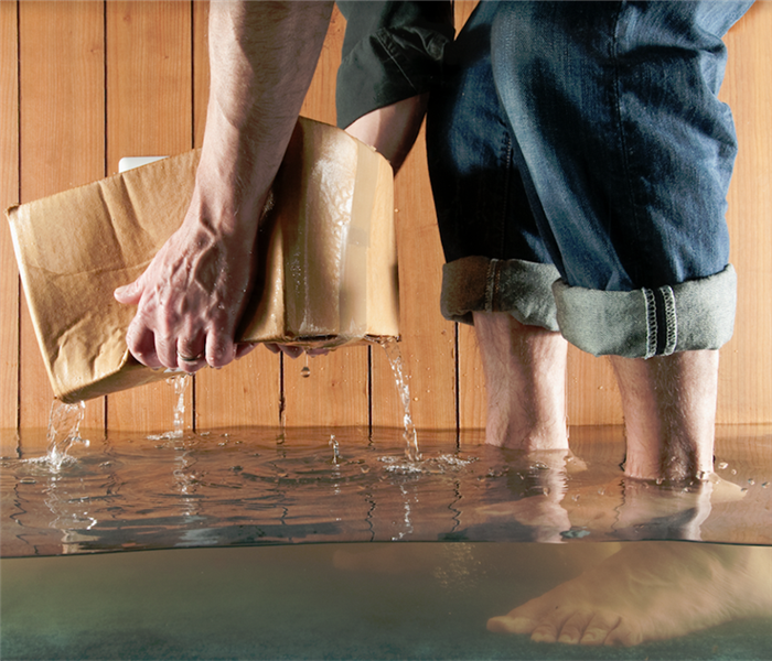 a person standing in a room with water covering the floor